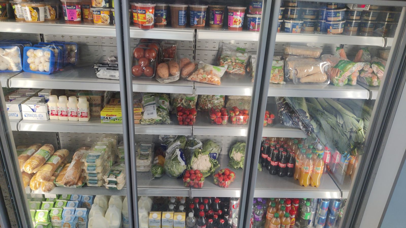 Chilled fridges with salad, vegetables, strawberries, milk, dairy and soft drinks