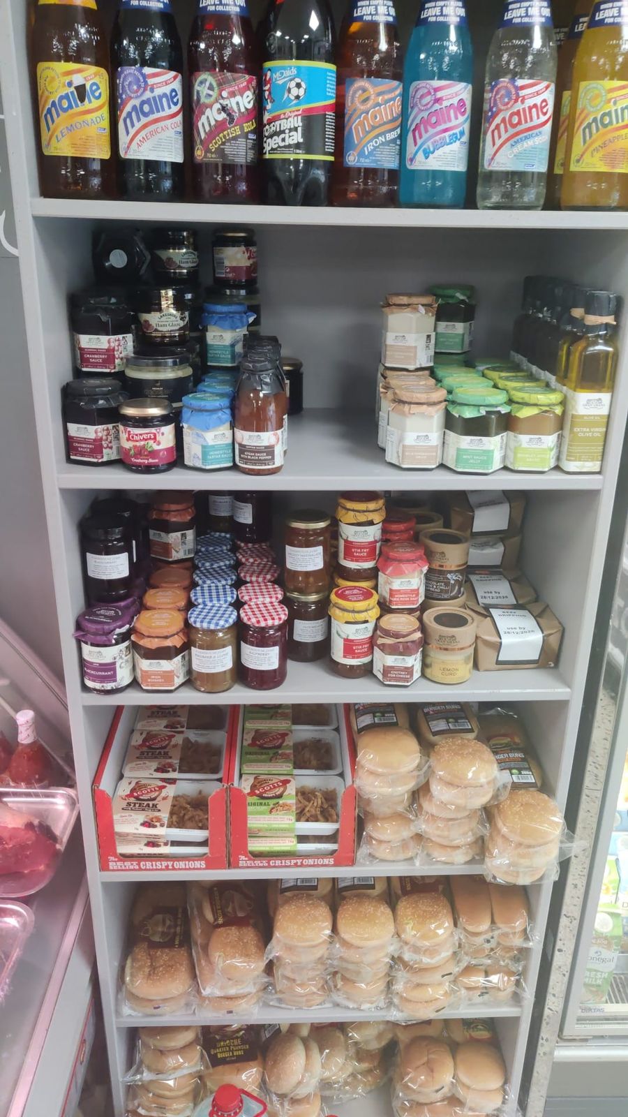 Shelves of Maine minerals, jams, chutneys, oils, crispy onions and burger buns